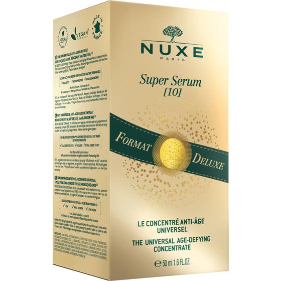 Nuxe Super Serum 50 ml anti-aging serum kvinne som drypper konsentrat med gylne perler fra en pipette i hånden