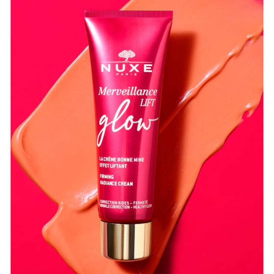 Nuxe Merveillance Lift Glow 50 ml kiinteyttävä päivävoide, jonka persikkainen koostumus valuu punaisesta tuubista.