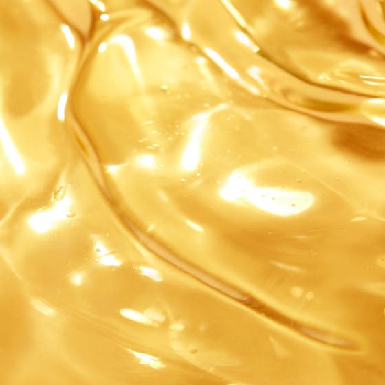 Nuxe Sun Tanning Oil 150 ml sololje SPF30 gir glød i en oransje sprayflaske nedsenket i glitrende vann