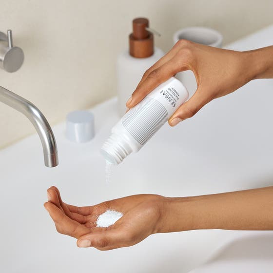 Sensai Silky Purifying Deep Clean Kit eksfolierende peeling powder hældes som hvidt pulver ud i håndfladen.