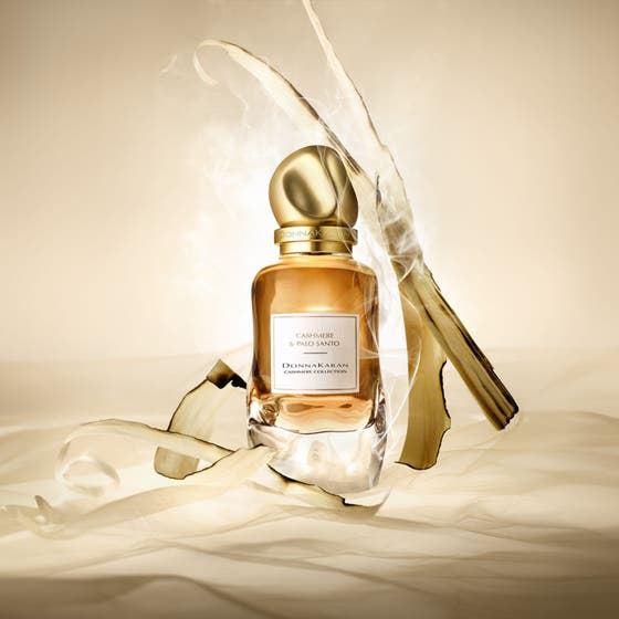 DKNY Cashmere Collection Palo Santo 100 ml Eau de Parfum i glasflaska med guldkork omgiven av rökig palo santo