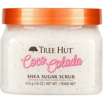 Tree Hut Coco Colada Shea Sugar Scrub 510 g mjukgörande kroppsskrubb i burk med vitt kornigt innehåll och orange lock