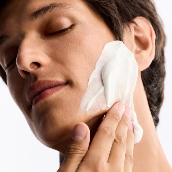 Nuxe Men Shaving Foam 150 ml anti-irritasjon barberingsskum i brun boks på hvit, bølget og kremet bakgrunn.