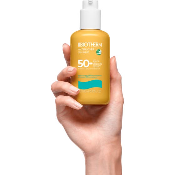 Biotherm Waterlover Sun Milk SPF50 200 ml fuktighetsgivende solkrem i gul pumpeflaske plassert på lys sand.