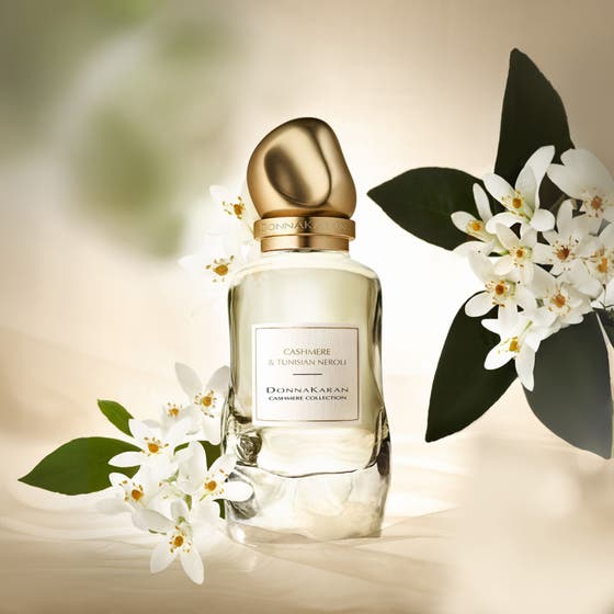 DKNY Cashmere Collection Tunesian Neroli Eau De Parfum 100 ml i glasflakon med guldhætte og hvide blomster