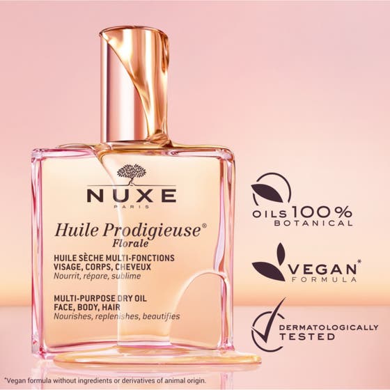 Nuxe Huile Prodigieuse Florale 100 ml nærende tørrolje i en rosa glassflaske som står på skrå mot en rosa bakgrunn