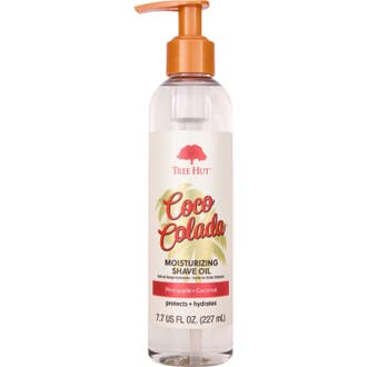 Tree Hut Coco Colada 227 ml återfuktande rakolja i en genomskinlig pumpflaska med orange detaljer och palmblad.