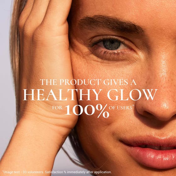Nuxe Sun-Kissed Fluid SPF 30 40 ml solkrem for ansiktet i oransje tube mot en glitrende bakgrunn