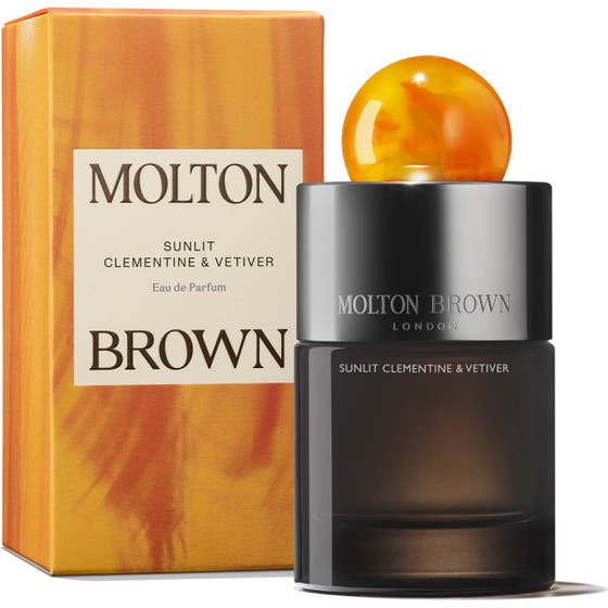Molton Brown Sunlit Clementine & Vetiver EdP 100 ml tummassa lasipullossa oranssilla korkilla ja pakkauksella