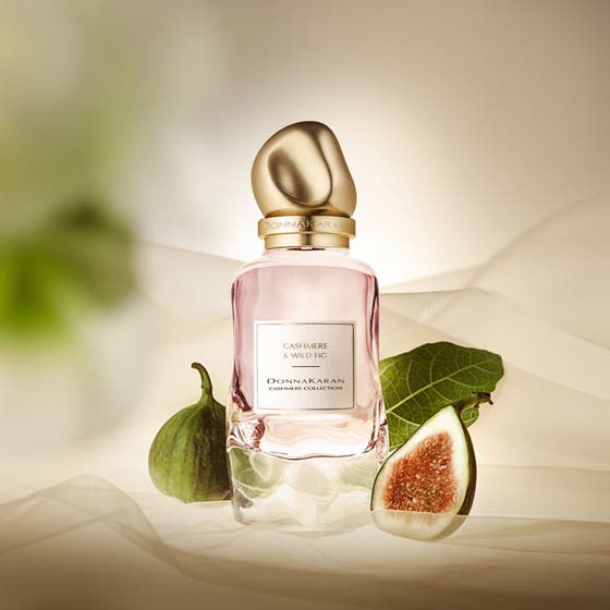 DKNY Cashmere Collection Wild Fig 100 ml parfym dam i rosa flaska med guldkork omgiven av fikon och gröna blad