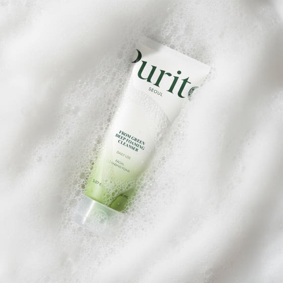 Purito From Green Deep Foaming Cleanser 150 ml skonsam rengöring i vit tub med svart lock som hålls i en hand.