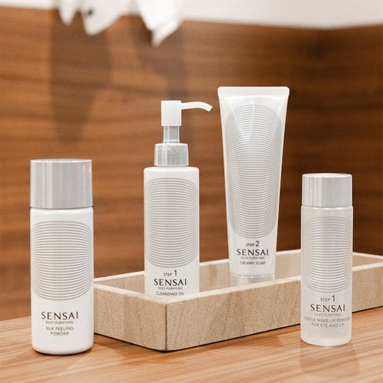 Sensai Silky Purifying Deep Clean Kit hudplejesæt med hvide flasker og tuber i en stenbakke der giver ren hud