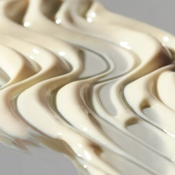 Dermalogica Biolumin-C Heat Aging Protector 50 ml SPF50 dagkrem i hvit pumpeflaske med gulldetaljer holdt av person.