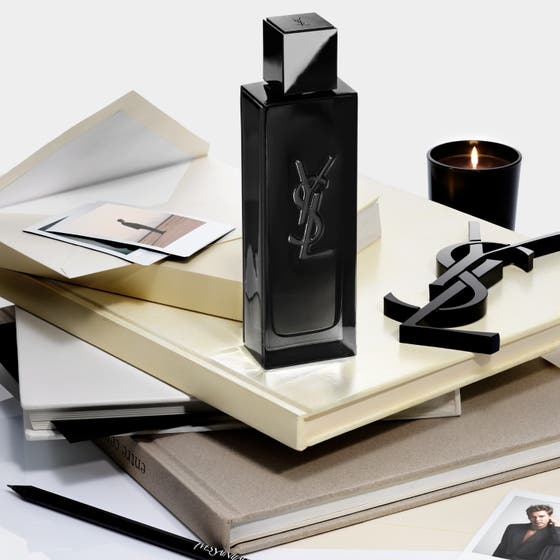 Yves Saint Laurent MYSLF Eau de Parfum 40 ml herreparfyme i sort glassflaske plassert på bøker ved siden av et tent lys