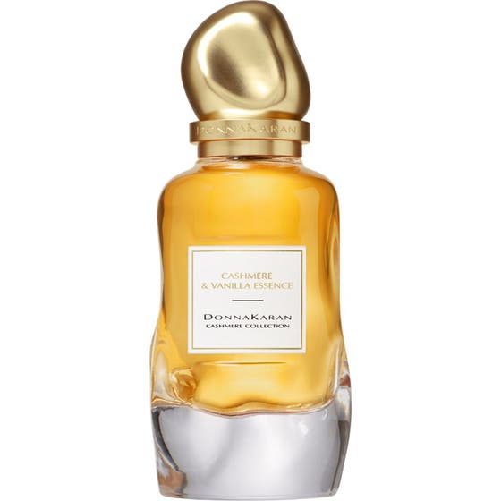 DKNY Cashmere Collection Vanilla Essence Eau De Parfum 100 ml i en vågig glasflaska med gul vätska och guldig kork