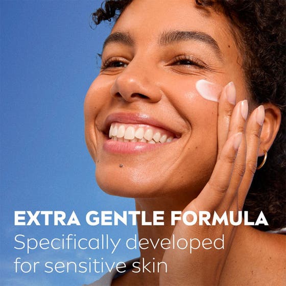 NIVEA Soothing Day Cream 50 ml för känslig hy appliceras på en leende kvinna mot blå bakgrund.