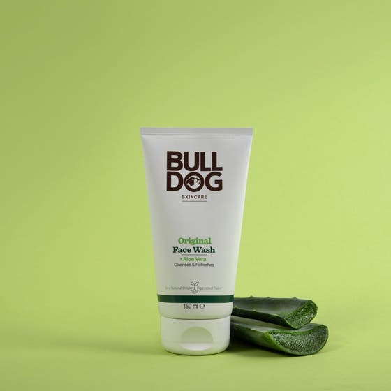 Bulldog Original Face Wash 150 ml ansiktsrengöring i vit tub som rengör huden bredvid färska aloe vera-blad.