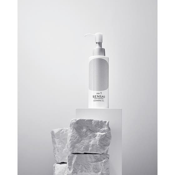 Sensai Silky Purifying Cleansing Oil ansigtsolie i hvid pumpeflaske der giver ren hud placeret på hvide sten.